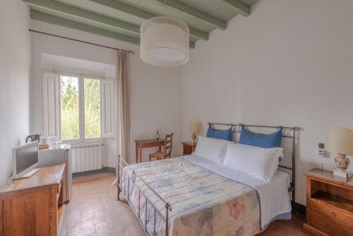 a bedroom with a bed and a television in it at Castello Di Meleto in Gaiole in Chianti