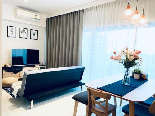 a living room with a blue couch and a table at Veranda Residence pattaya By Sea in Jomtien Beach