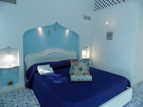 een blauwe kamer met een bed met blauwe lakens en kussens bij Maison de charme Villa Mavi in Praiano