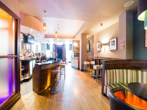 a bar in a restaurant with tables and chairs at OYO Imperial Hotel in Barrow in Furness