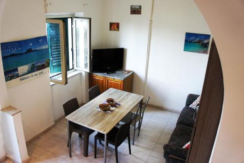 a dining room with a table and a tv at Casa Vacanze Cayohouse in Messina