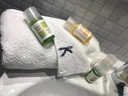 a bathroom sink with a towel and a bottle of soap at Hotel Khella in Hammamet