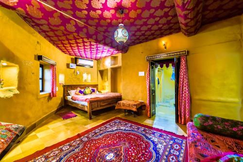 a bedroom with a bed and a rug in a room at Mud Mirror Guesthouse in Jaisalmer