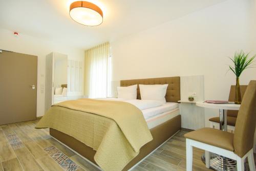 a bedroom with a bed and a desk and a chair at Hotel Filderhof Reutlingen in Reutlingen