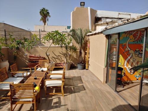 an outdoor patio with wooden chairs and tables at Sapir Boutique Apartments in Beer Sheva