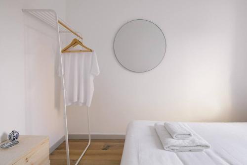 a white bedroom with a bed and a mirror at The Interlock Apartments - Oxford St in London