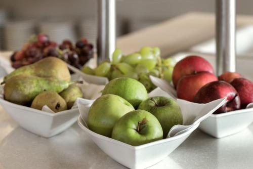 a group of bowls of apples and pears on a counter at Tyrifjord Hotell in Vikersund