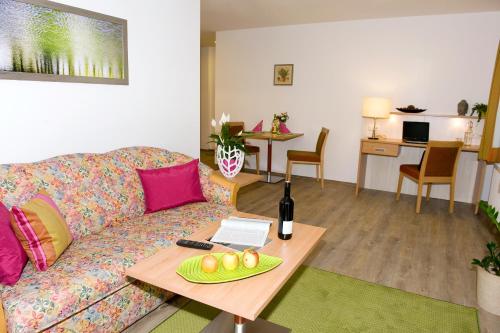 uma sala de estar com um sofá e uma mesa com uma garrafa de vinho em Ferienwohnungen - Boarding Wohnungen Sonnenhof em Lenzing