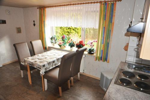 uma cozinha com mesa e cadeiras e uma janela em Ferienwohnung Am Königsmoor, 65323 em Moormerland
