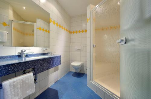 a bathroom with a shower and a sink and a toilet at Landhotel RÖSSLE in Stimpfach