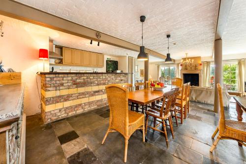 a kitchen and dining room with a table and chairs at De Appelgaard in Sint-Martens-Voeren