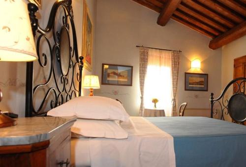 1 dormitorio con 1 cama con cabecero de hierro forjado en Borgo Mandoleto - Country Resort & Spa, en Solomeo