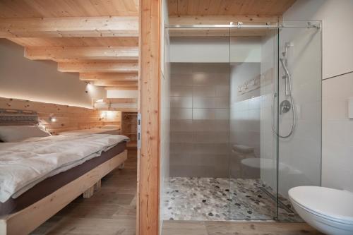 a bedroom with a shower and a bed and a toilet at Agriturismo Soreie - Farmstay in Vigo di Fassa