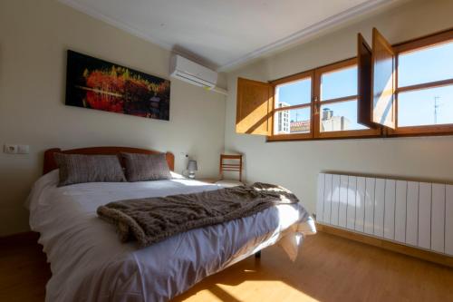 1 dormitorio con cama y ventana grande en Duplex completo junto a la Plaza Mayor en Salamanca