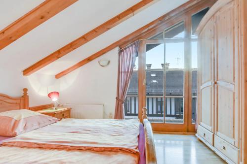 um quarto com uma cama e uma grande janela em Katharinenhof Ferienwohnung Hausberg (6) em Garmisch-Partenkirchen
