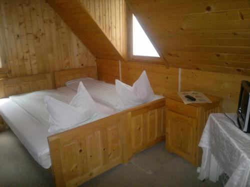1 dormitorio con 1 cama en una cabaña de madera en Cabana Dara en Cumpăna