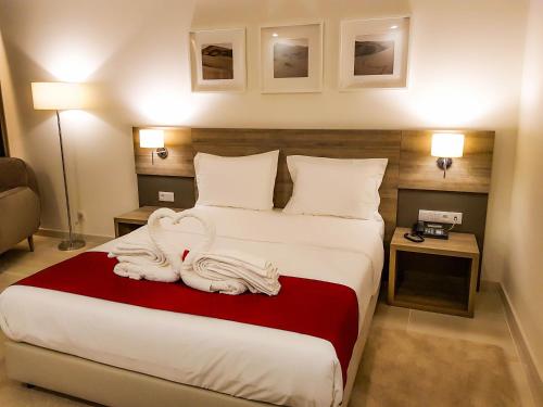 a hotel room with a bed with towels on it at Hotel Monotel Dar El Barka in Nouakchott