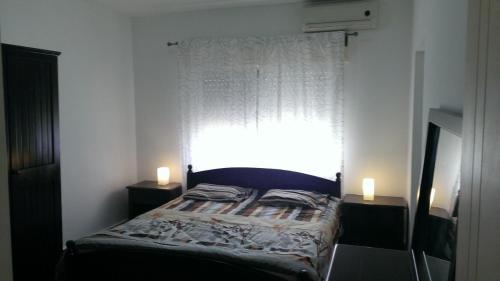 a bedroom with a bed and a window with two candles at 3BR Apartment Simple and clean in Rujm ash Sharāʼirah