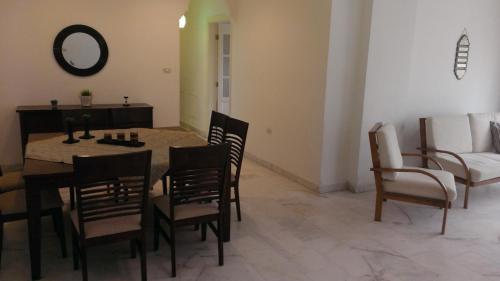 sala de estar con mesa, sillas y sofá en 3BR Apartment Simple and clean en Rujm ash Sharāʼirah