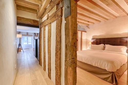 une chambre avec un lit et un mur en bois dans l'établissement Luxurious & Design Flat 2BR/8P- Boulevard Saint Germain, à Paris