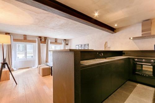 - une cuisine avec des placards vert foncé et une cuisinière dans l'établissement Luxurious & Design Flat 2BR/8P- Boulevard Saint Germain, à Paris