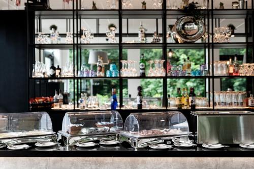 ヴァリゼレンにあるB&B HOTEL Zürich Wallisellenのカウンターの皿とグラスが並ぶテーブル