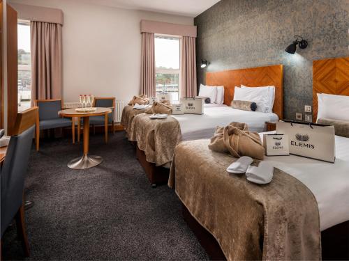 a hotel room with three beds and a table at Treacy’s Hotel Spa & Leisure Club Waterford in Waterford