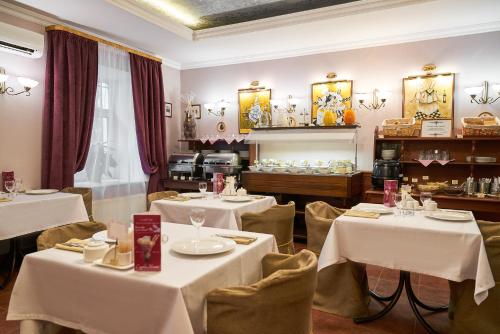 Admiralteyskaya Hotel في سانت بطرسبرغ: مطعم بطاولات وكراسي مع طاولة قماش بيضاء