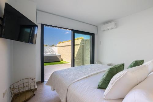 a bedroom with a white bed and a large window at Sea Breeze Villas in Playa Blanca