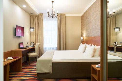 Admiralteyskaya Hotel في سانت بطرسبرغ: غرفة في الفندق مع سرير ومكتب
