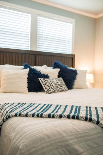 a bed with blue and white pillows on it at Walk to the Silos! 3 Bed 1960's Bungalow near Baylor in Waco