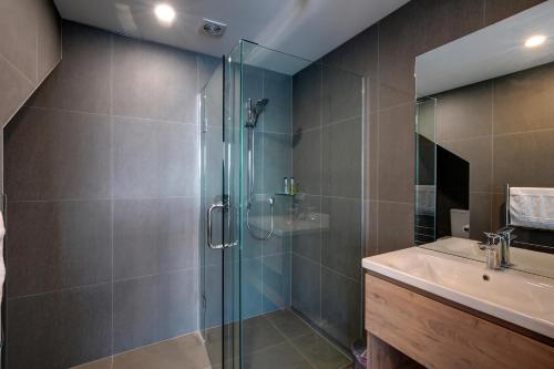 a bathroom with a glass shower and a sink at Falcon's View Queenstown in Queenstown