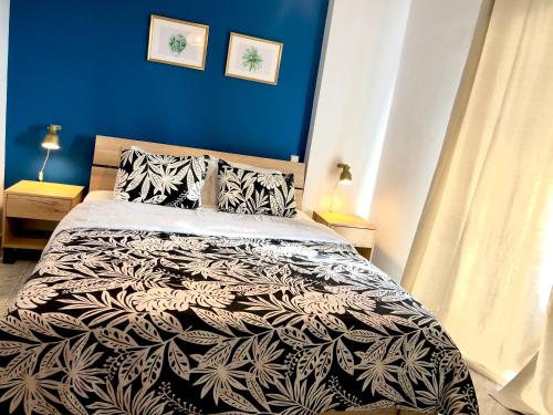 a bedroom with a bed with a black and white comforter at Anastasias house near Athens airport in Spáta