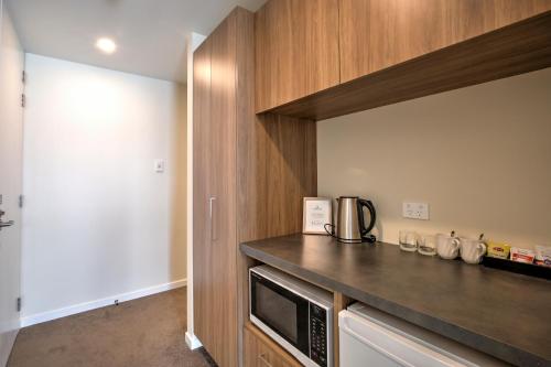 a kitchen with a counter top and a microwave at Falcon's View Queenstown in Queenstown