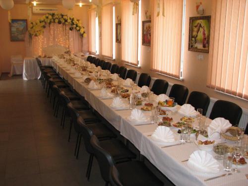 a long table with white tables and chairs in a room at Art Hotel in Izmail
