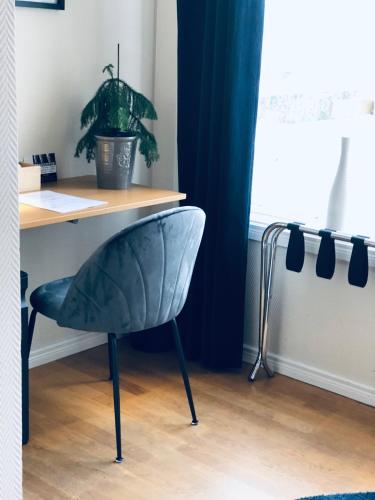 a chair sitting in front of a desk with a plant at Treetop Spa Hangout & Hotel in Gothenburg