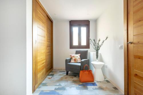 a hallway with a chair and a vase at Apartamentos Ejemplares in Alcalá de Henares