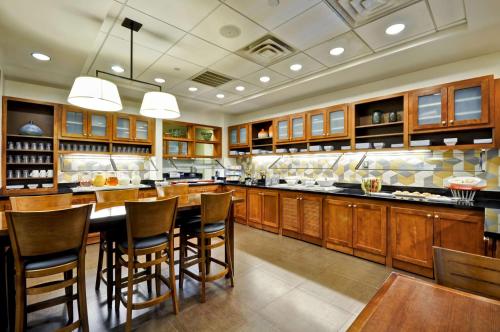 a large kitchen with wooden cabinets and a table and chairs at Hyatt Place Minneapolis Airport South in Bloomington