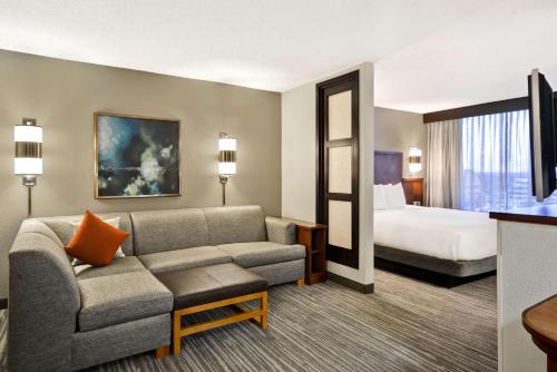 Hyatt Place Columbus Worthington في ورثينجتون: غرفة في الفندق مع أريكة وسرير