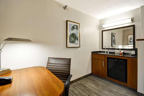 um quarto com uma secretária, uma mesa e um espelho em Hyatt Place Kansas City/Overland Park/Metcalf em Overland Park