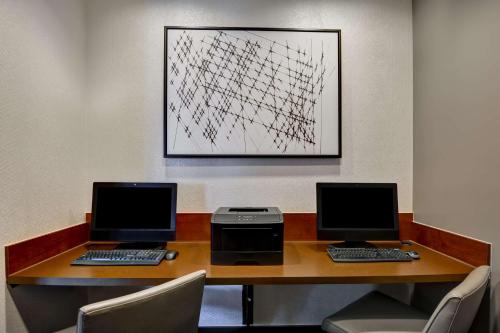 two computers sitting on a desk with chairs at Hyatt Place Memphis Wolfchase in Memphis