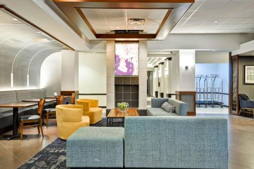- un hall avec des canapés, une table et des chaises dans l'établissement Hyatt Place Tampa Airport/Westshore, à Tampa