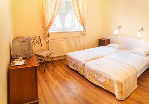 a bedroom with two beds and a television in it at Villa Sipeky in Senec