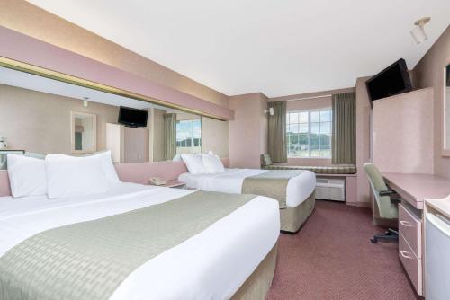 Microtel Inn La Crosse Onalaska Area tesisinde bir odada yatak veya yataklar