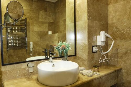 a bathroom with a sink and a mirror at Konyak Hotel in Yerevan