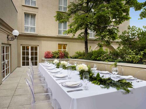 a long table with white plates and flowers on it at The Novotel Toronto Centre in Toronto