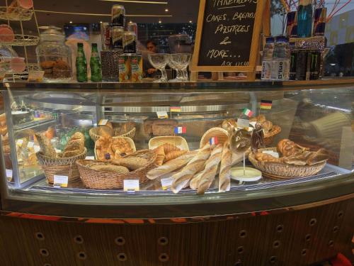 a display case in a bakery with baskets of bread at Novotel Ahmedabad in Ahmedabad