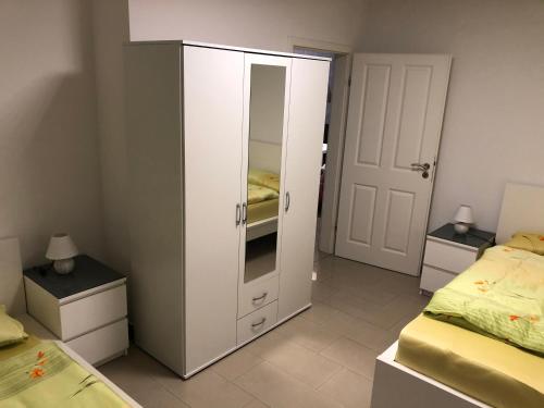 einen weißen Schrank in einem Schlafzimmer mit 2 Betten in der Unterkunft 4realax in Mülheim an der Ruhr