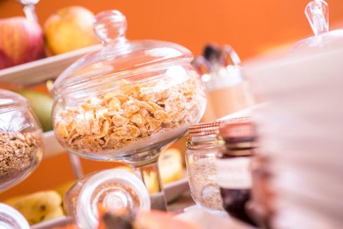 ein Glasbehälter gefüllt mit Müsli und anderen Lebensmitteln in der Unterkunft Pousada Armação de Camburi in Camburi