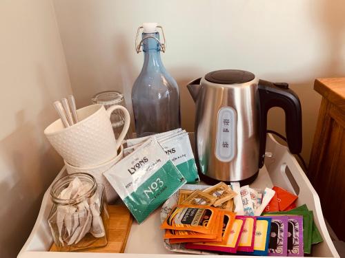 a counter with a coffee maker and a tea kettle at Hassop Station rooms on the Monsal Trail in Bakewell